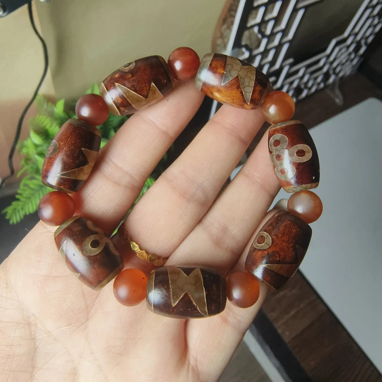 Distressed agate Tibetan bead bracelet with three-eye motifs and polished finish.
