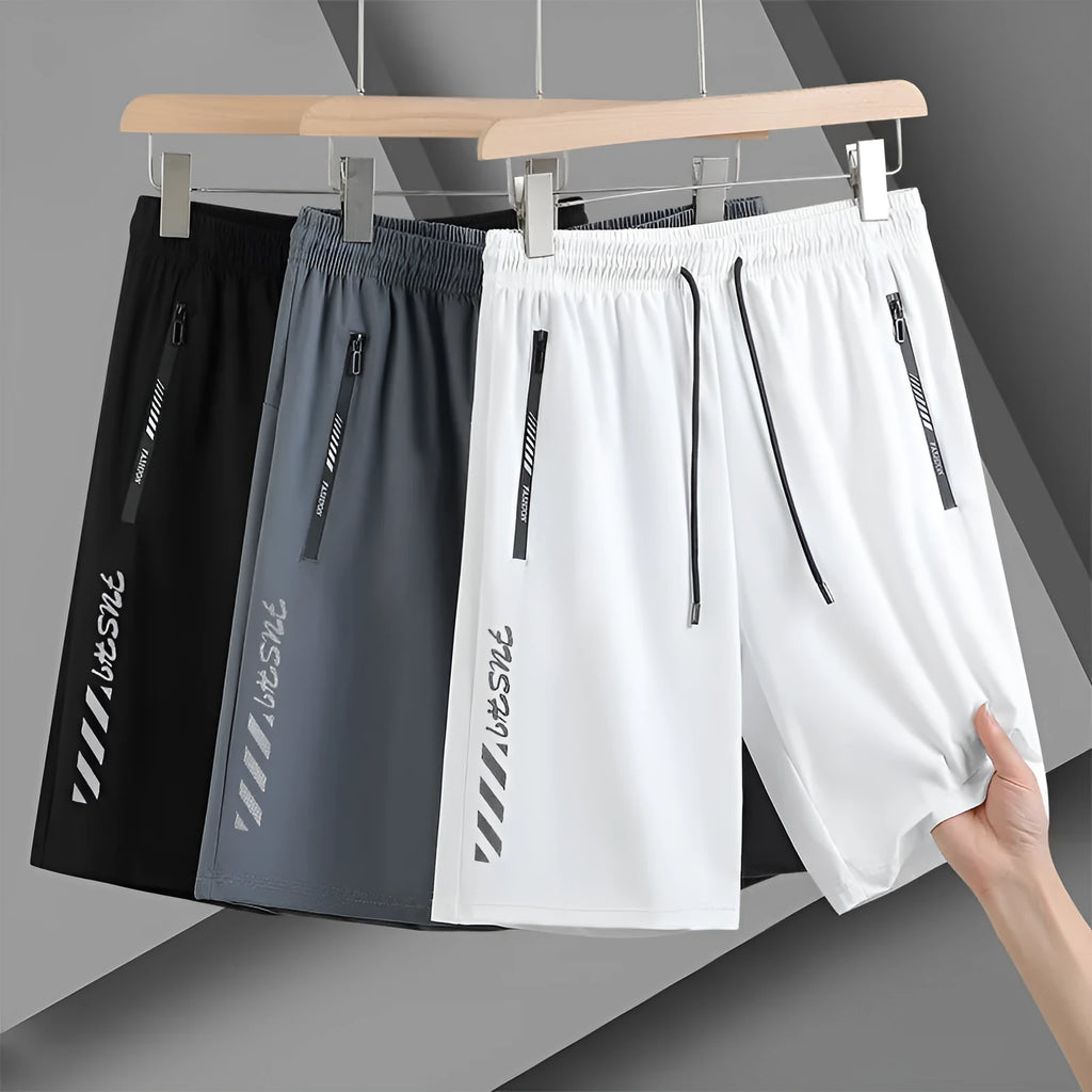 Men's black loose-fit nylon sports shorts with elastic waistband on a hanger