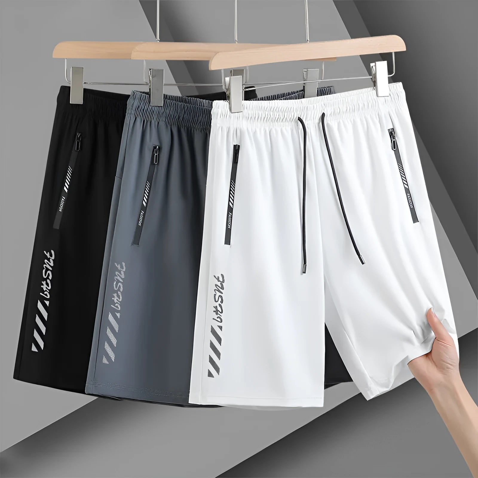 Men's black loose-fit nylon sports shorts with elastic waistband on a hanger