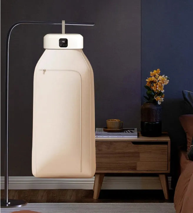 White cylindrical compact laundry dryer with remote control on countertop