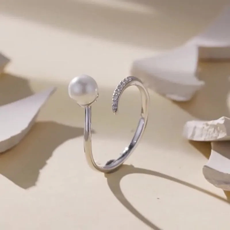 Women's adjustable sterling silver ring with shell pearls and open loop design