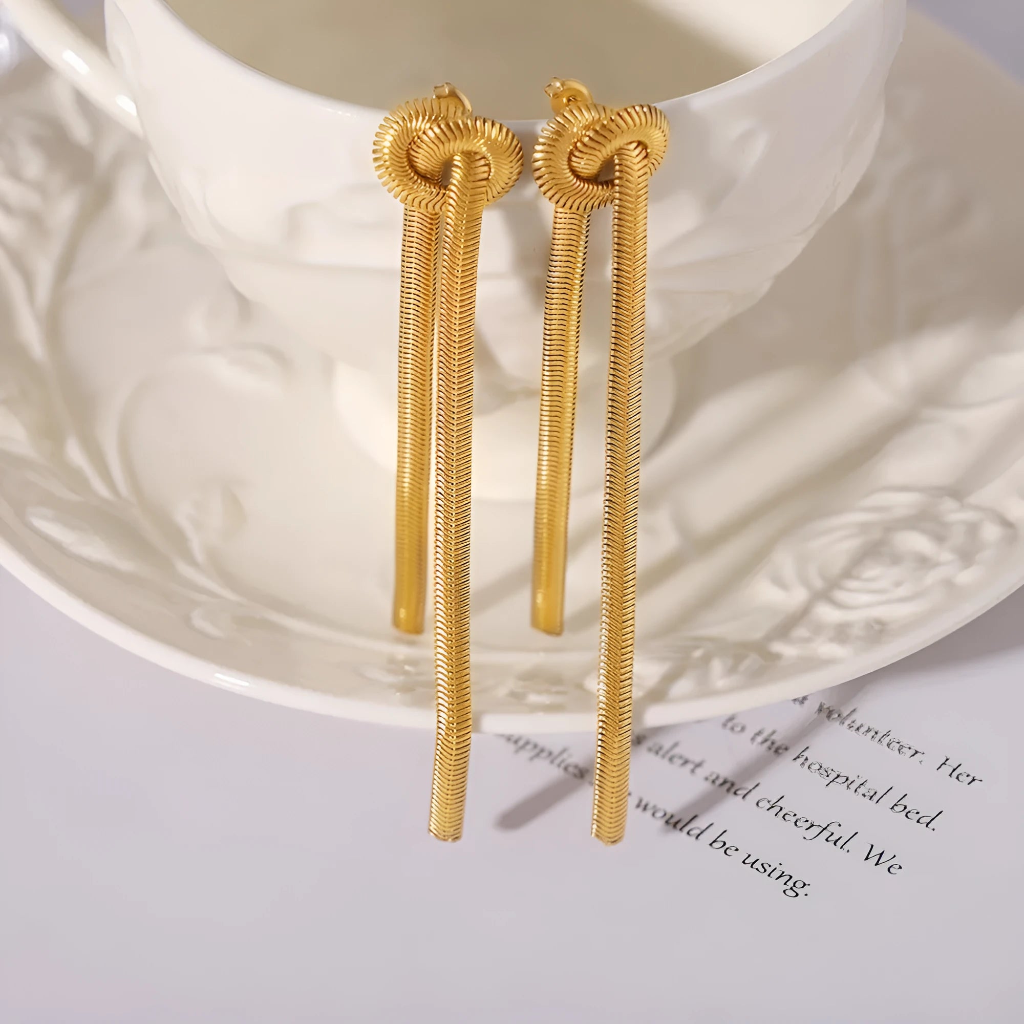 Gold electroplated titanium steel necklace with knotted tassel pendant and matching earrings