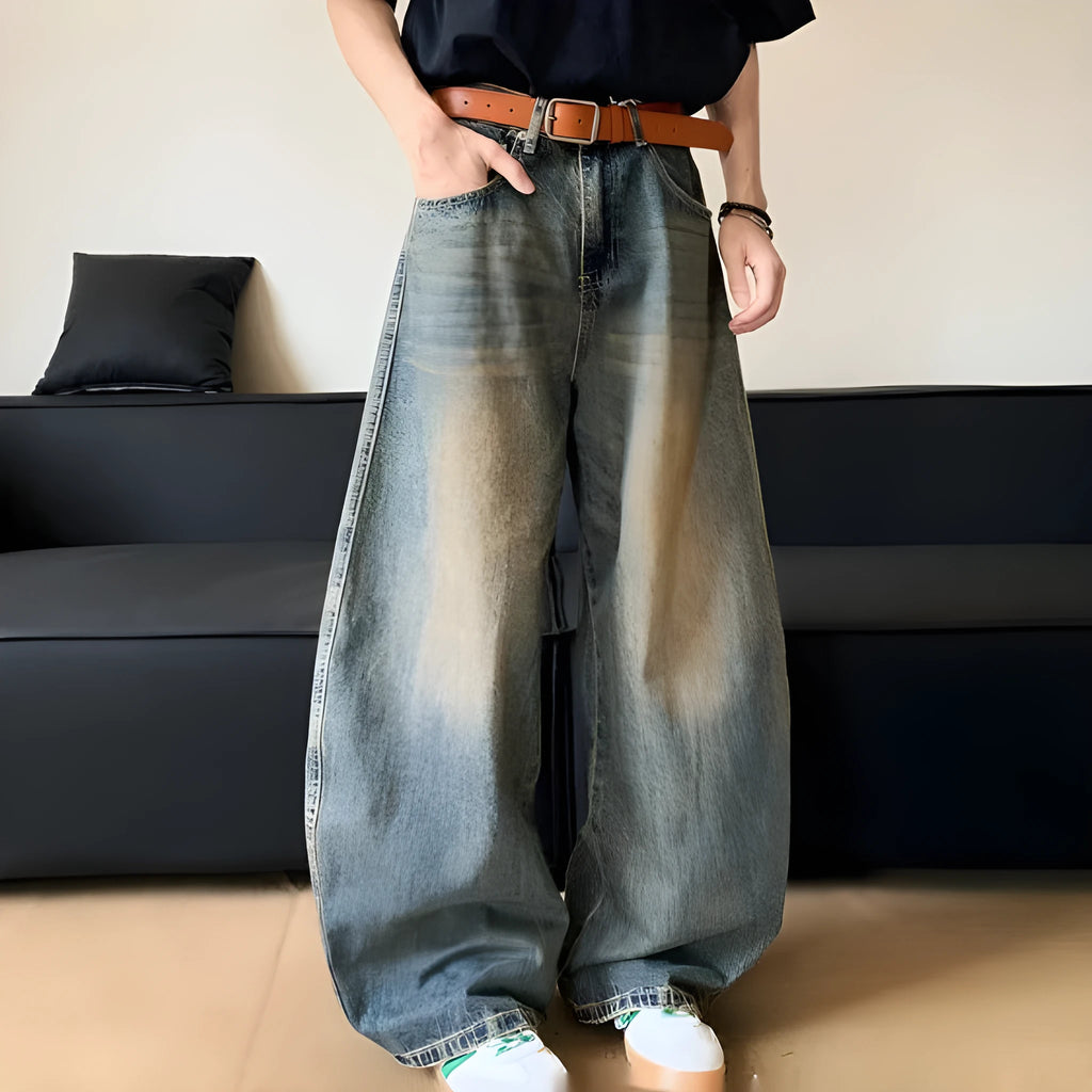 Men modelling retro blue distressed wide-leg jeans with machete detailing and a slimming fit.