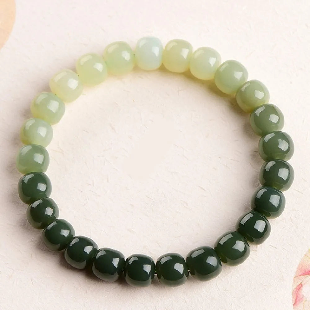 Natural Hetian jade bracelet showing a clear water gradient colour on polished beads.