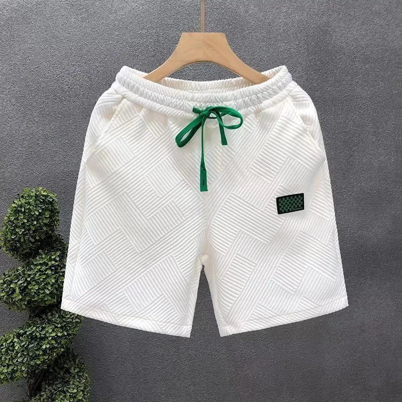 Men's solid colour polyester sports shorts with elastic waist in white, black and green options
