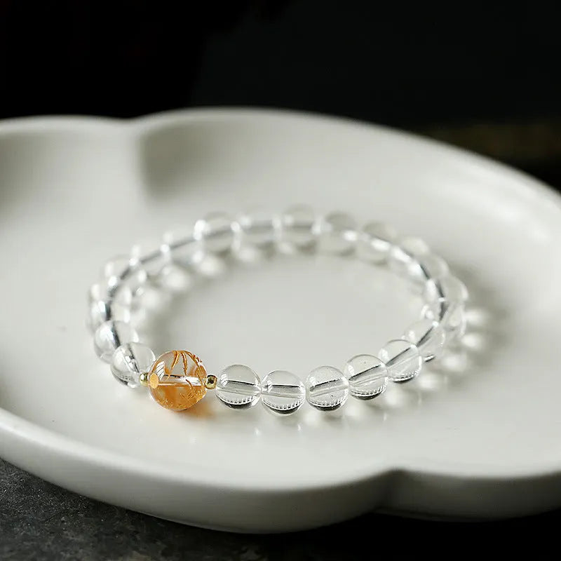 Geometric obsidian and white crystal unisex bracelet with a golden dragon bead on a wrist.
