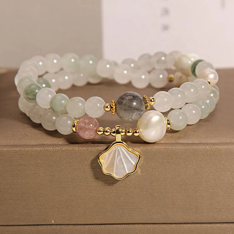 Women's emerald green crystal bracelet with gold ginkgo leaf pendant and rhinestone accents