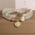 Women's emerald green crystal bracelet with gold ginkgo leaf pendant and rhinestone accents