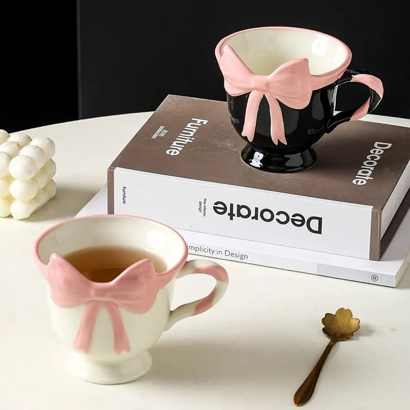 Ceramic mug with heart and bow design in white or black pink colours