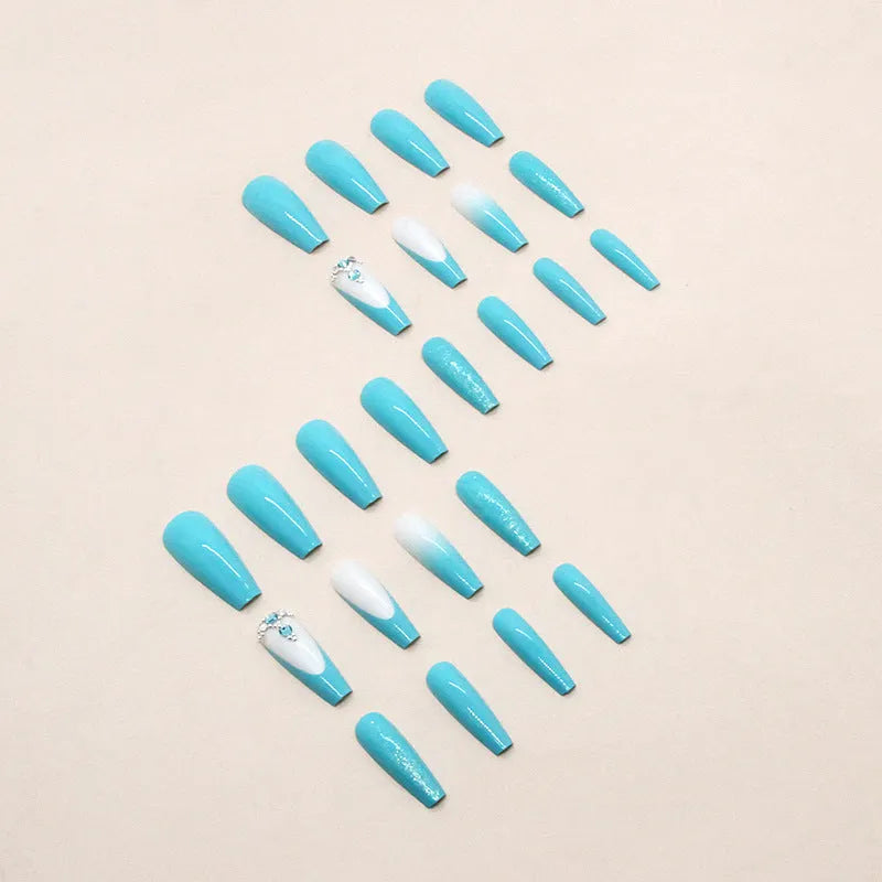 Long ballet false nails with blue diamond glitter on solid colour background with nail glue bottle