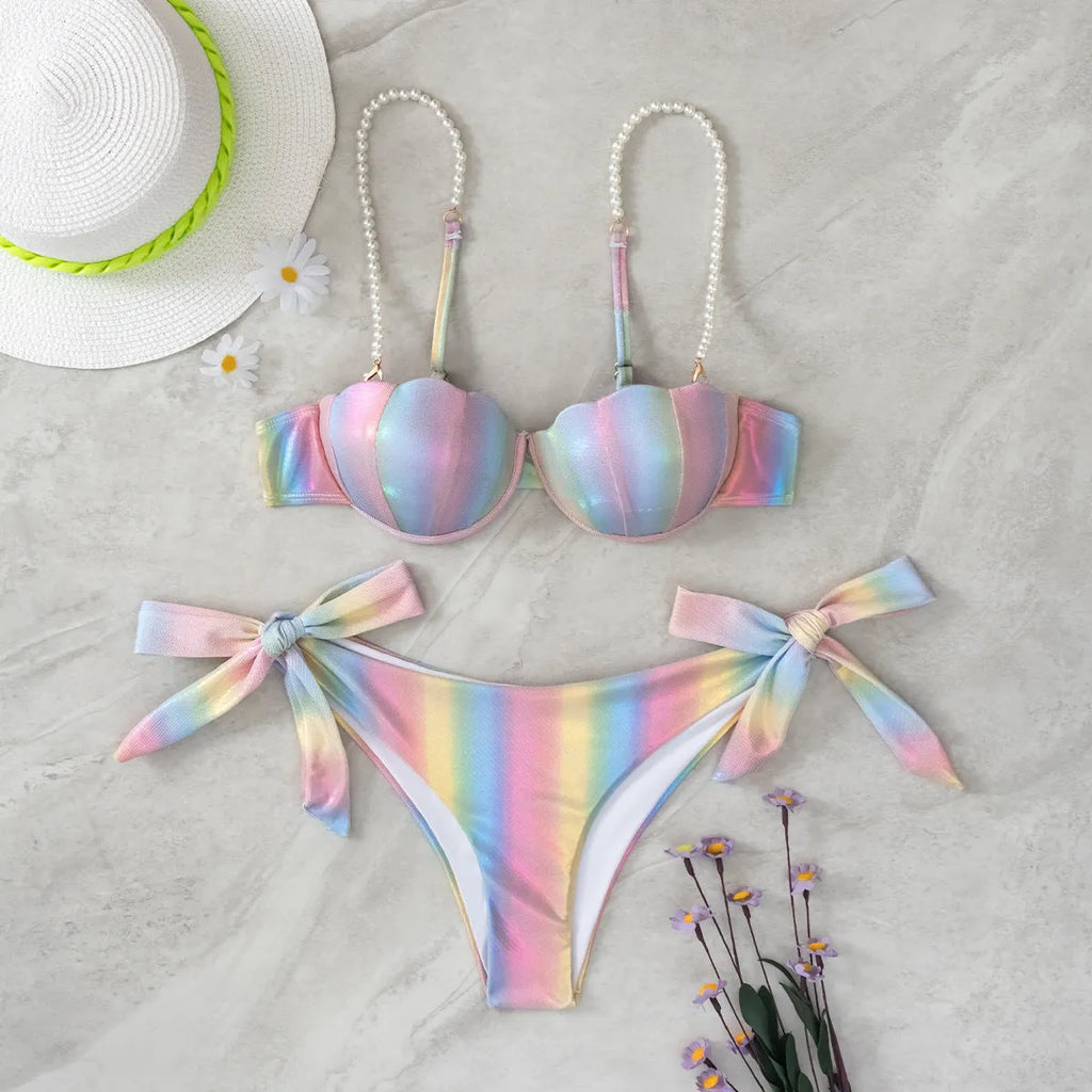 Women's rainbow tie dye bikini swimsuit with split tied sides on a model.