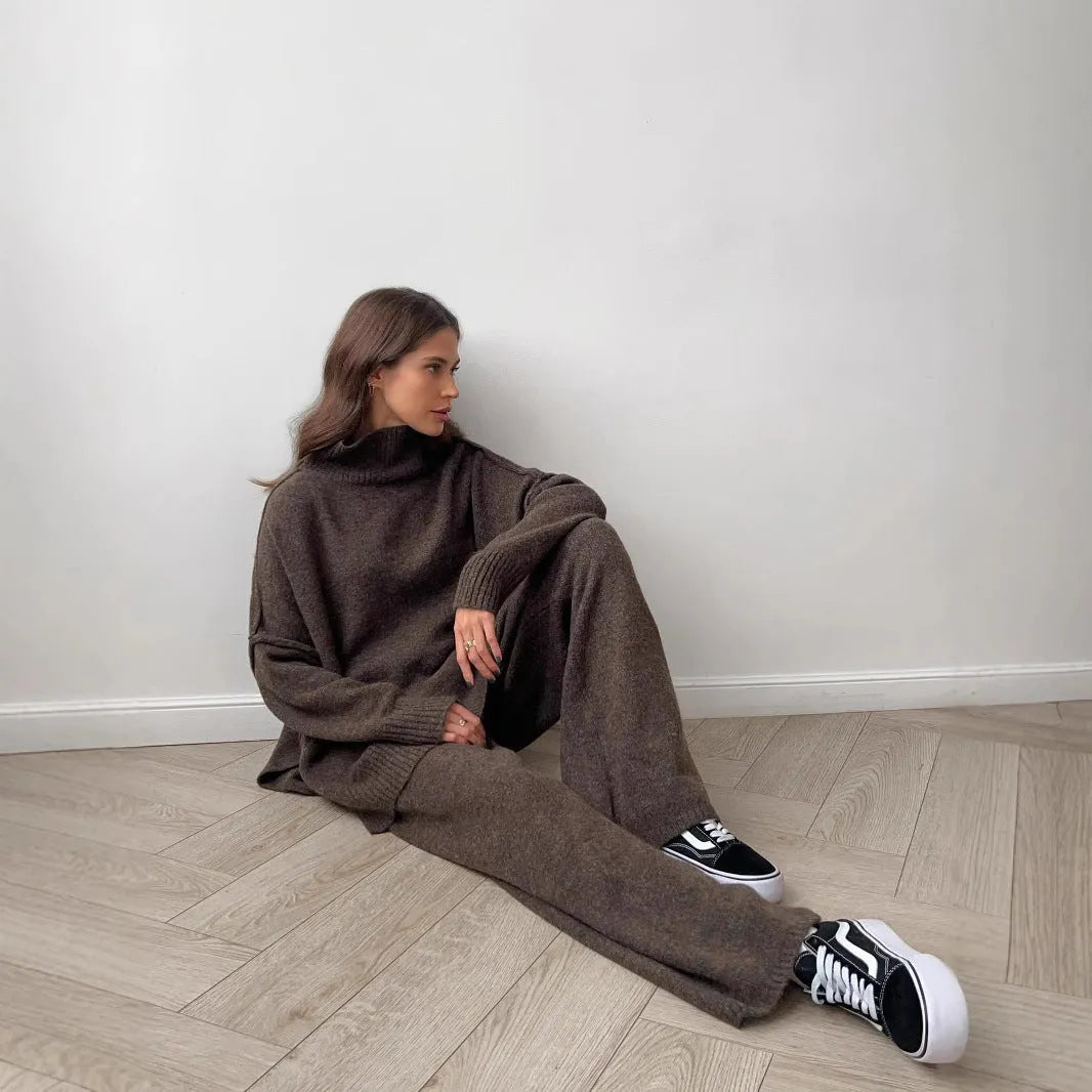 Women's dark grey acrylic jumper suit with side slits on the top and matching trousers.