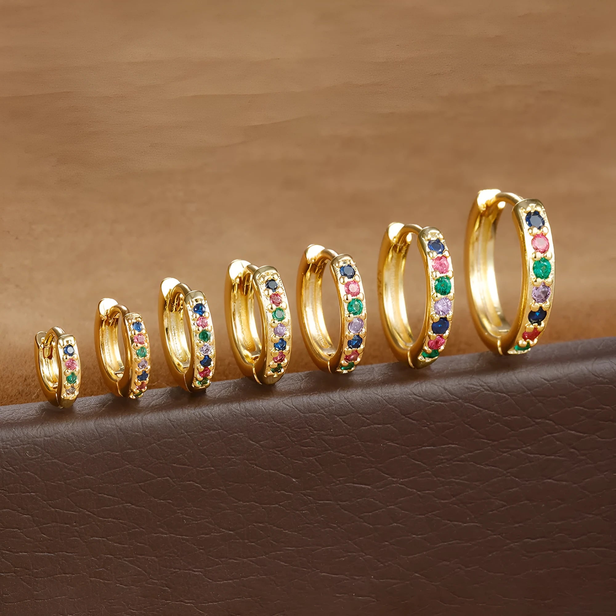 Geometric circle zircon stud earrings in gold, rose gold, or silver colour on a plain background.