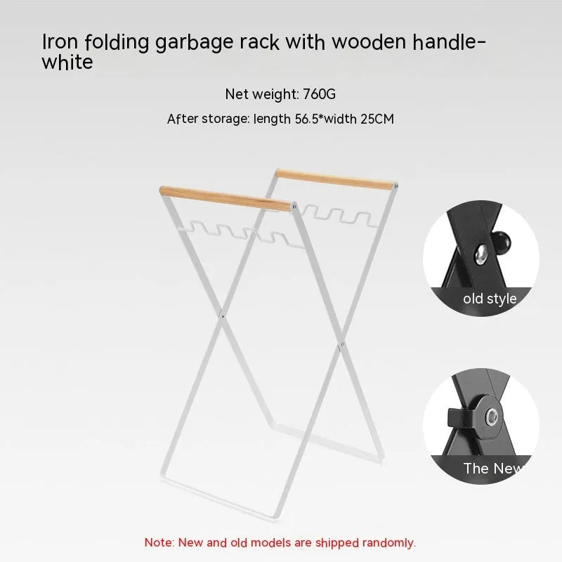Black foldable iron trash storage hanger with wooden handle holding a bin bag outdoors.