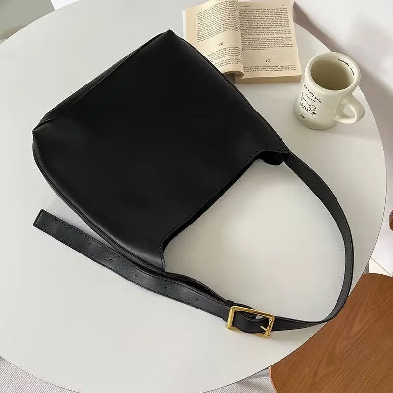 Women's soft PU leather shoulder bag with swing thread details in black or brown, showing dimensions of 28x32x12cm.