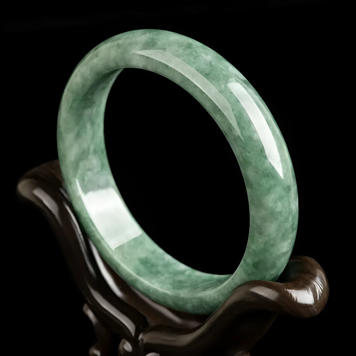 A simple dark pea green natural jade ring bracelet for women on a white background.