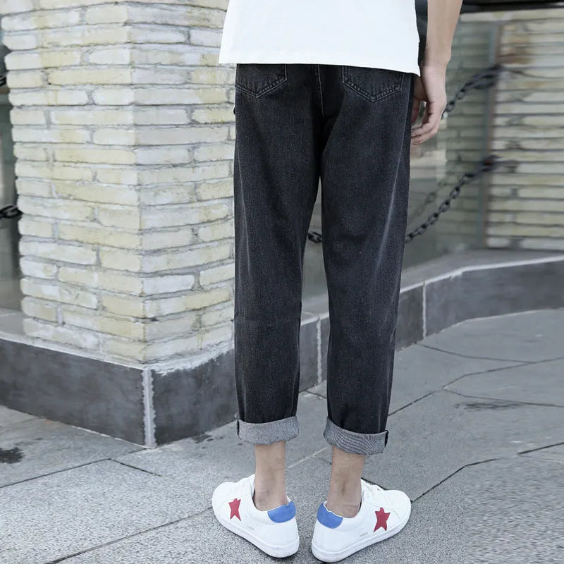 Man wearing loose straight leg cotton jeans in blue, showcasing the light straight open leg style.
