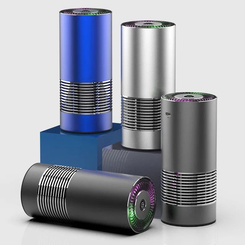 Compact cylindrical car air purifier in metallic grey with USB cable, shown next to a car vent for scale.