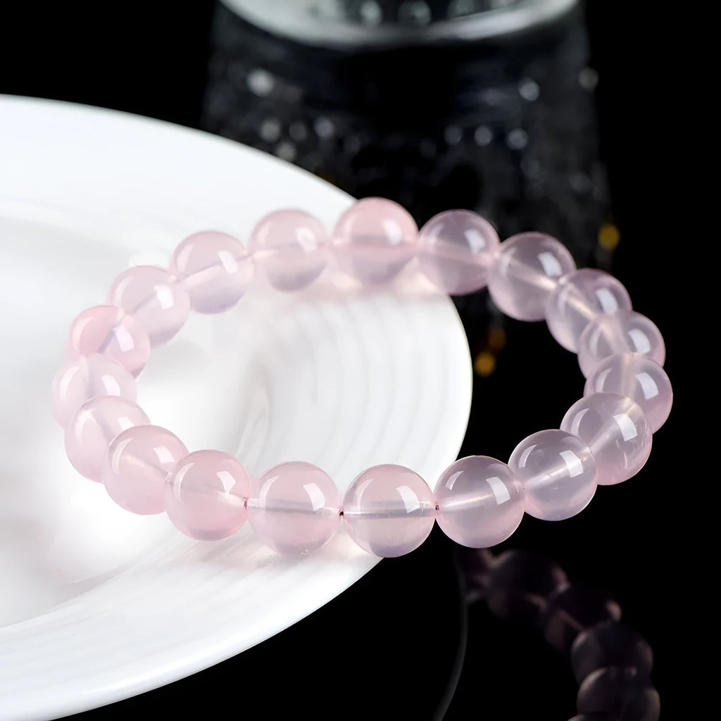 Natural starlight crystal round beads bracelet for women in pink, showing polished beads on a wrist.