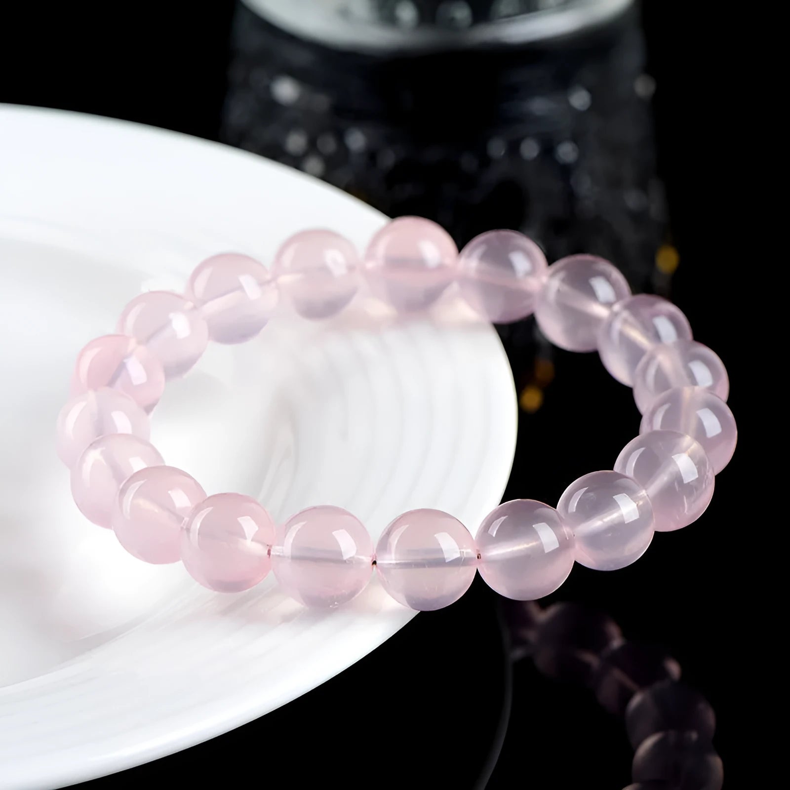 Natural starlight crystal round beads bracelet for women in pink, showing polished beads on a wrist.