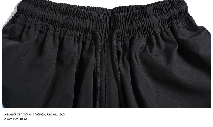 Men's loose fit quick-drying sports shorts in grey with elastic waist, shown above the knee.