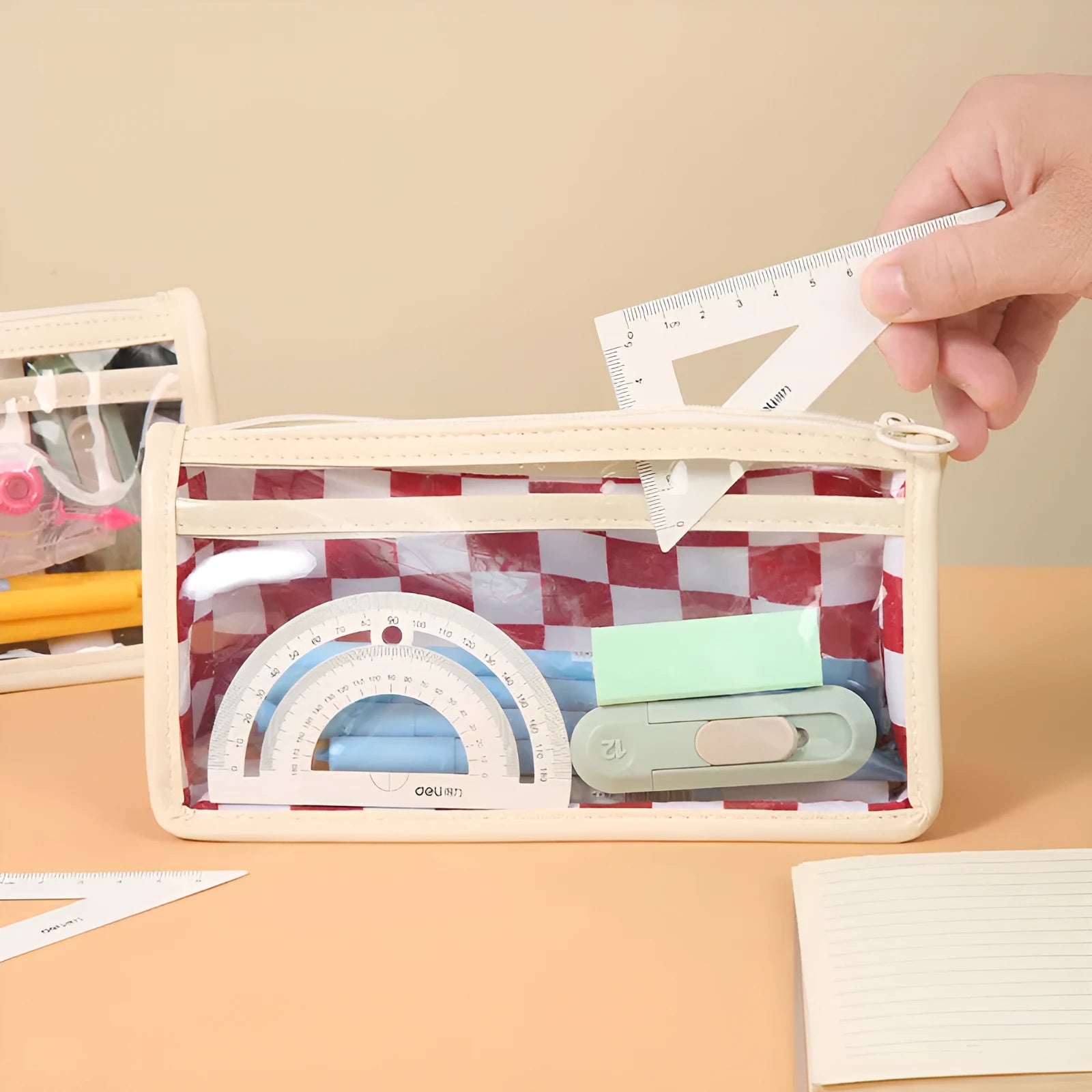 Transparent PVC pencil case with chessboard pattern showing pens inside, dimensions 21.5x8x11.5cm