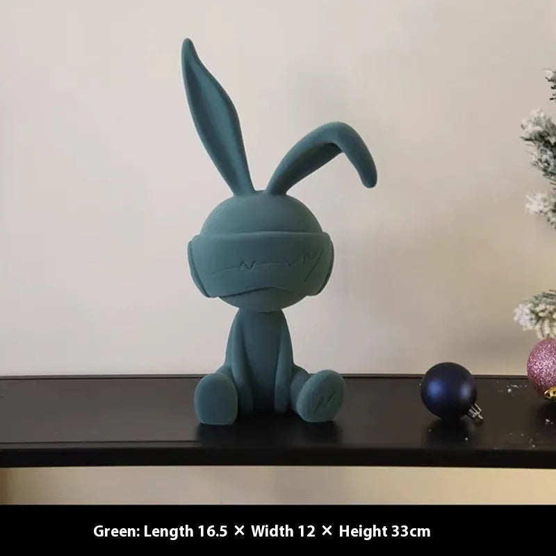 Green suede blindfold rabbit resin table ornament on a wooden desk