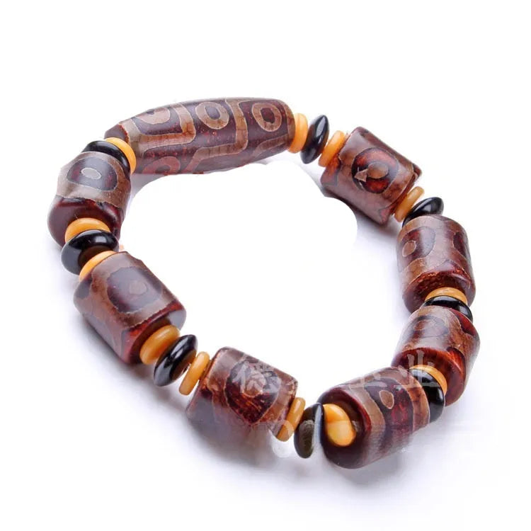 Distressed agate Tibetan bead bracelet with three-eye motifs and polished finish.