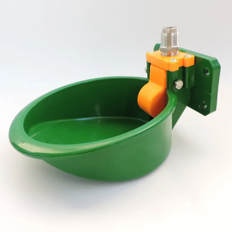 Green engineering plastic auto-drink water bowl for pigs and sheep on a farm.
