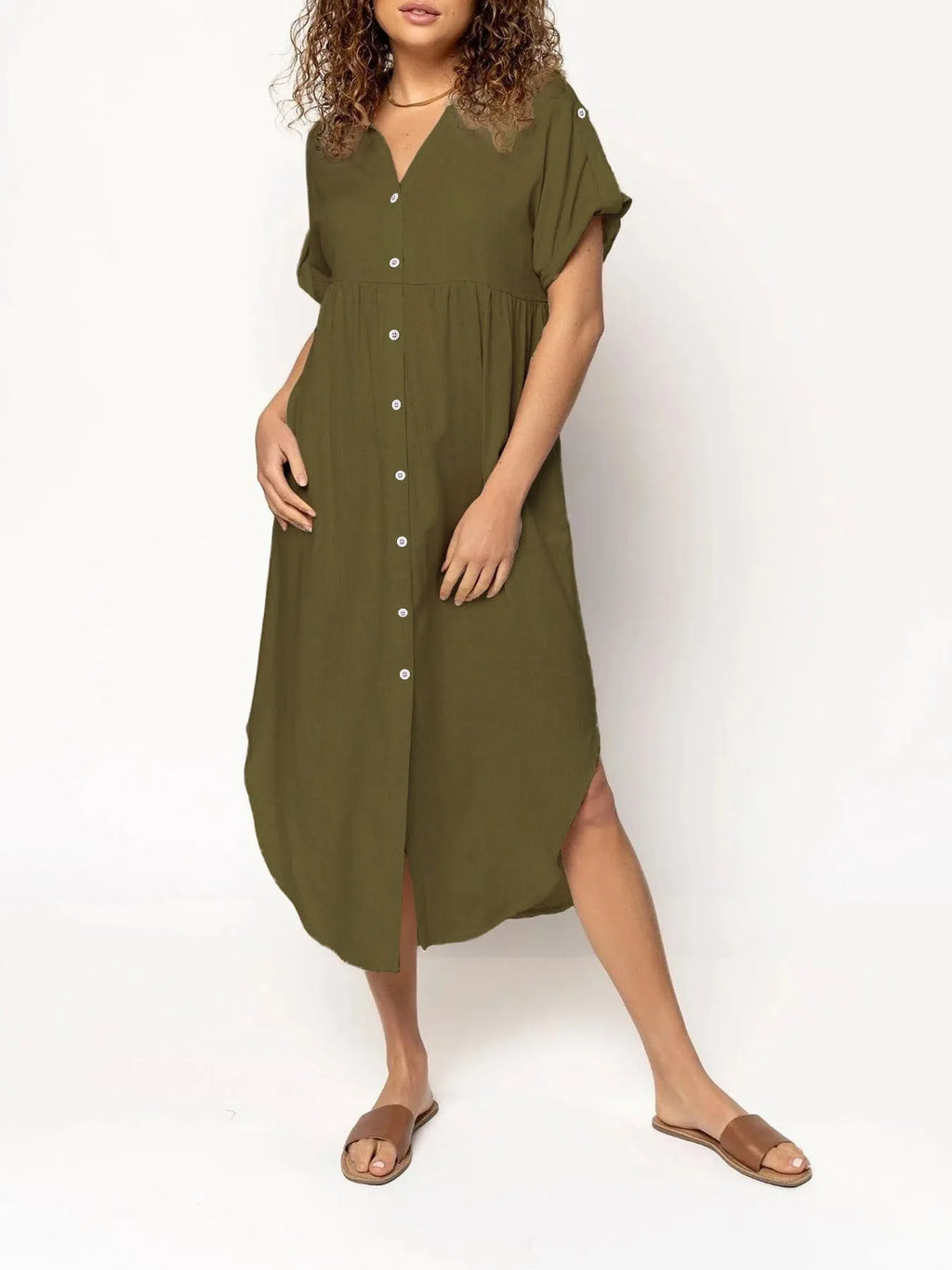A woman wearing a loose-fitting, mid-length apricot-coloured casual dress with a button-down front.