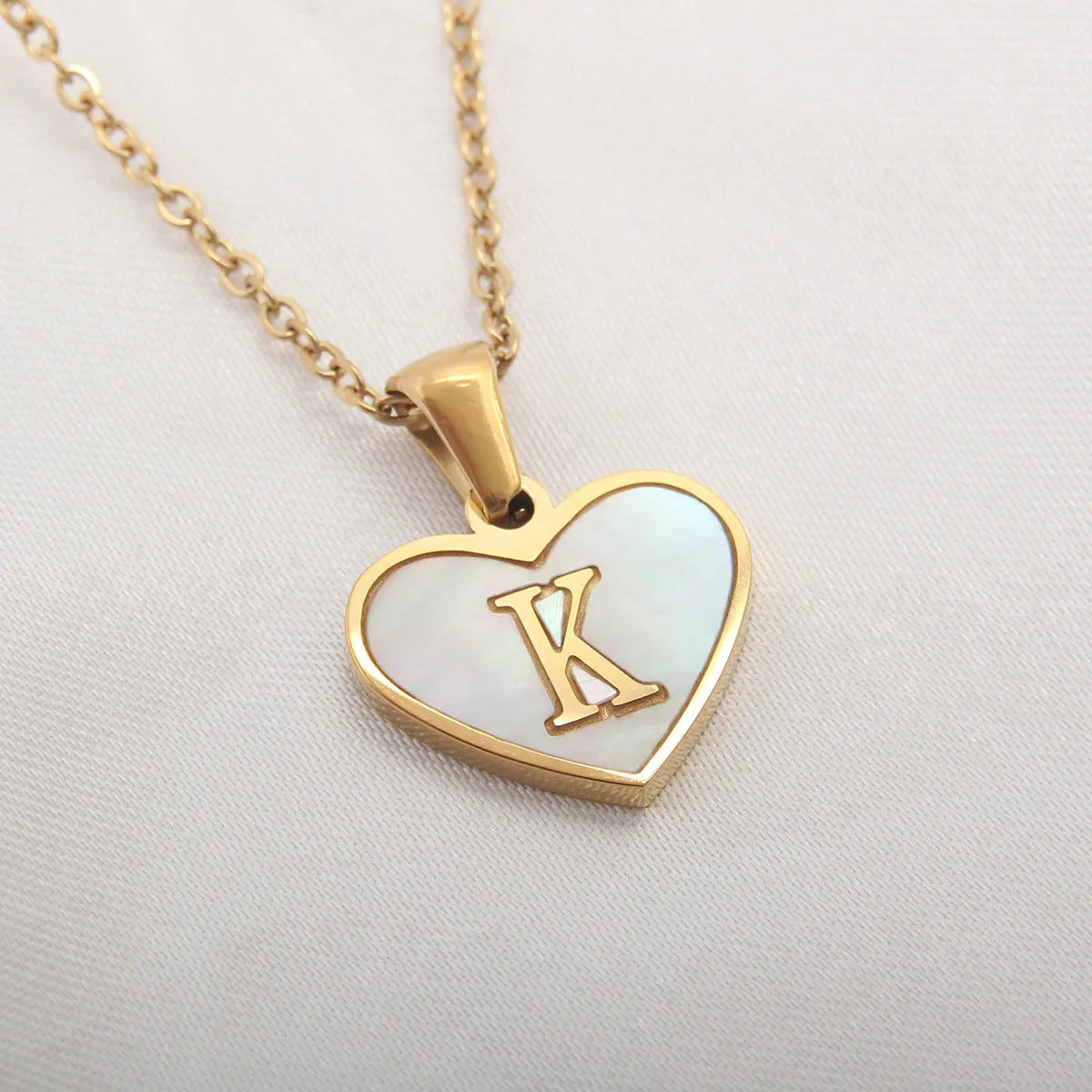 Gold plated initial necklace with white shell heart pendant and adjustable chain