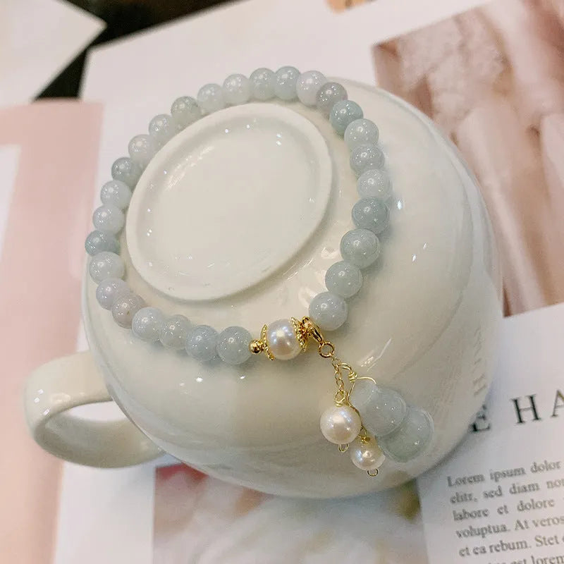 Chinese style gourd design jade bracelet for women with a pearl accent on a white background.