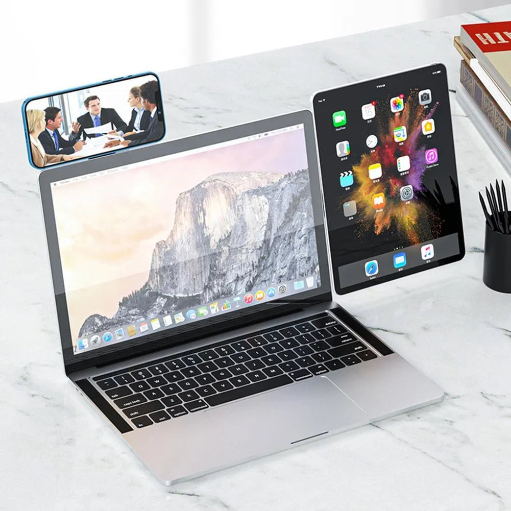 Black aluminum laptop phone holder mounted beside computer monitor showing smartphone attachment