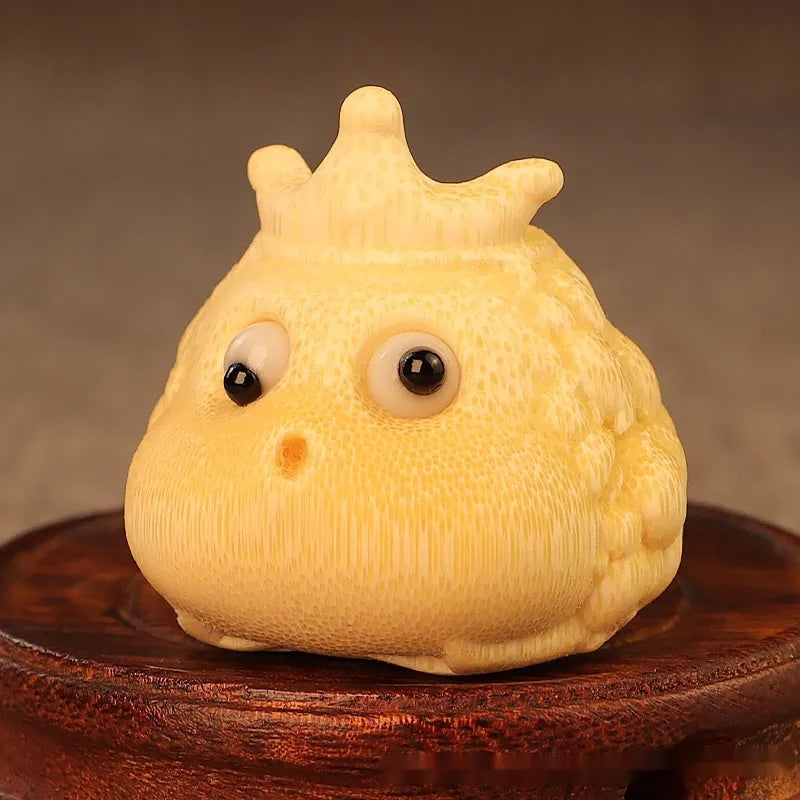 Solid bamboo carving of a cute style Crown Princess Toad ornament on display