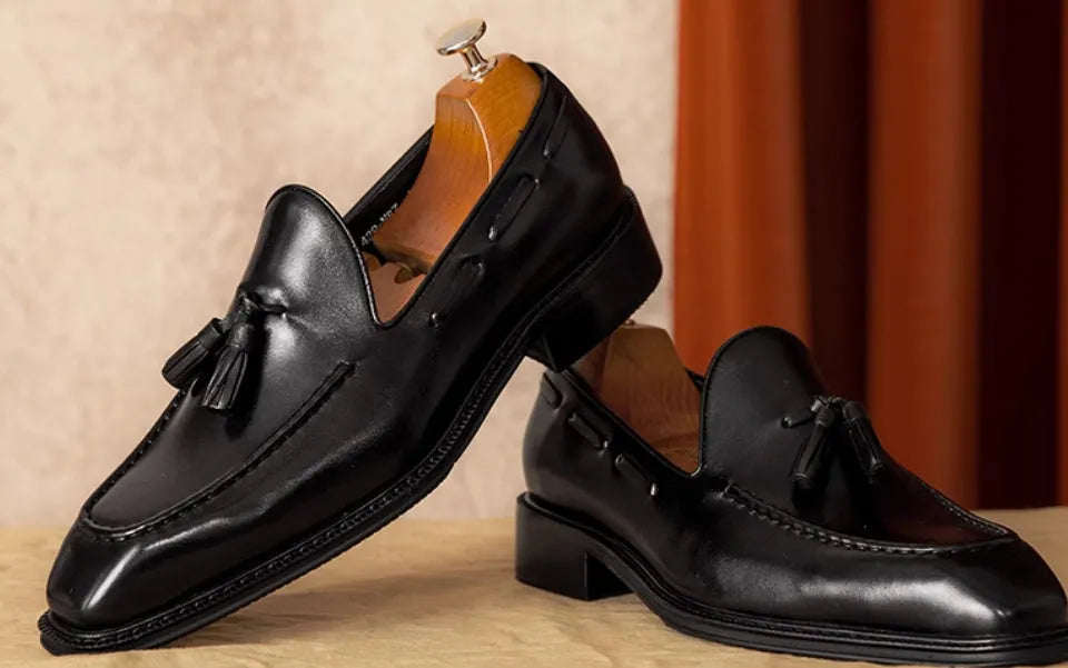 Men's black genuine leather slip-on loafers with fringed detailing and rubber sole