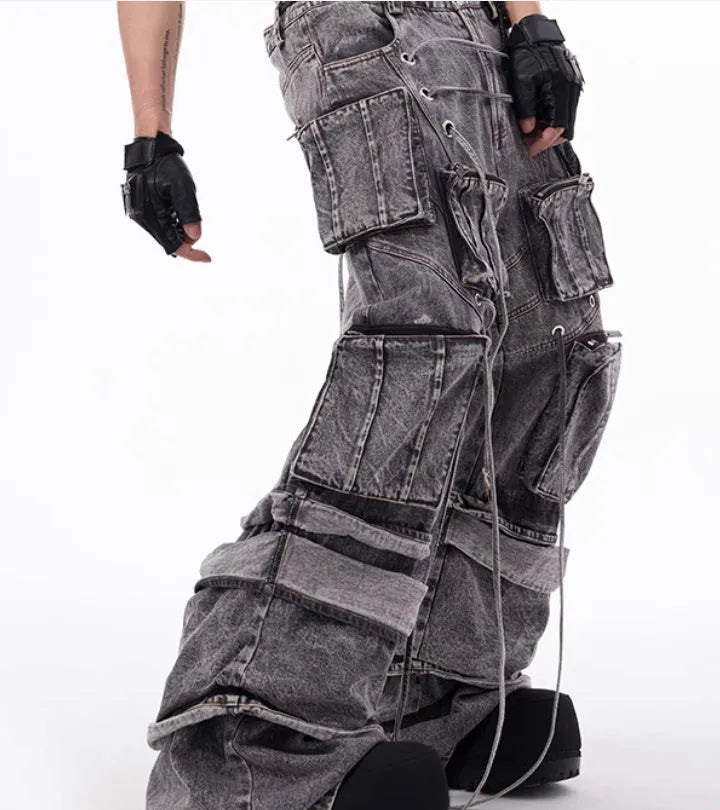 Grey distressed denim overalls with rope stitching on a hanger.