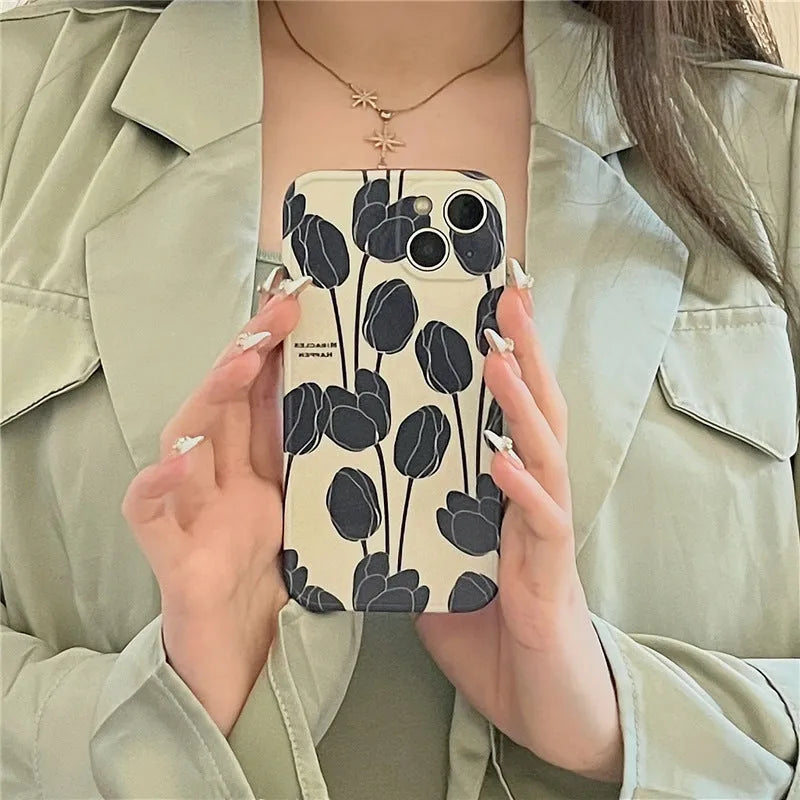 Black silicone iPhone case with a tulip floral pattern on the back.