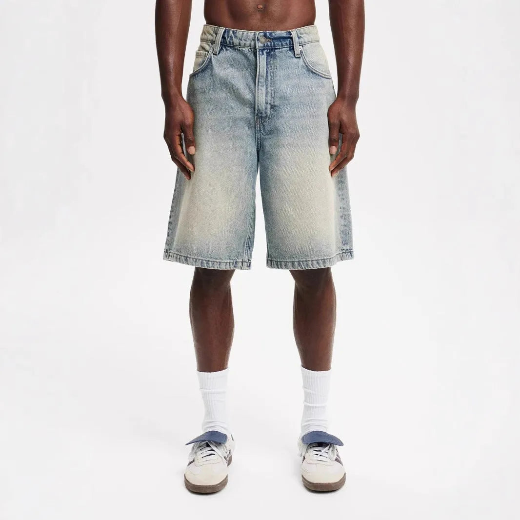 Men's loose straight-leg jeans in light blue denim on a neutral background