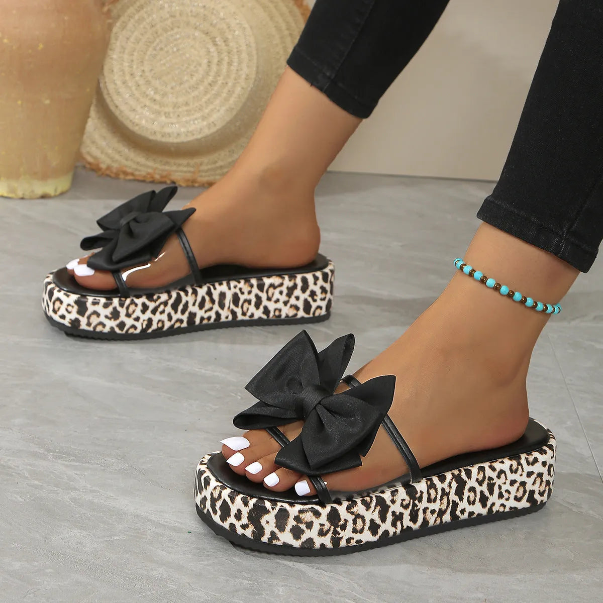 Women's white and black leopard print beach slippers with thick sole and round toe.