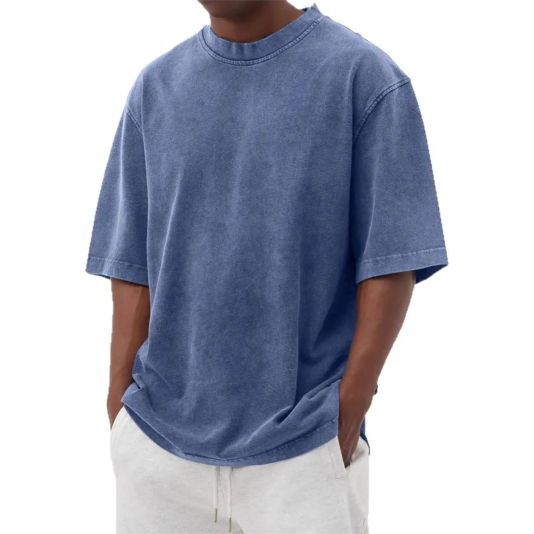 A man's loose-fit, stone-washed pullover t-shirt in a solid colour, shown on a hanger.