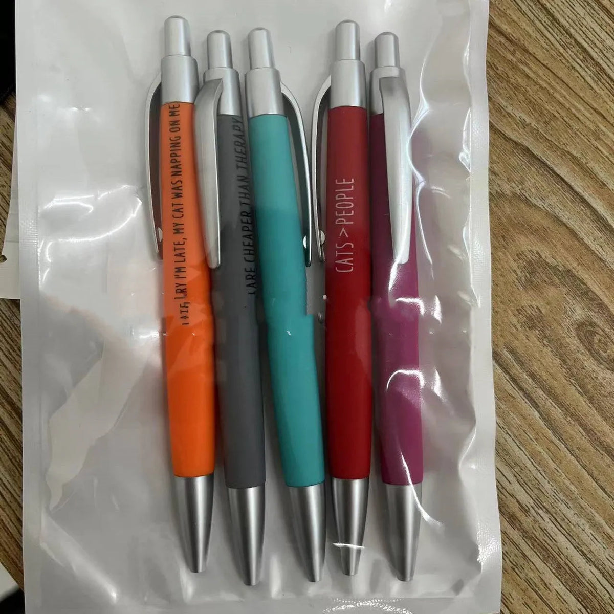 Set of five automatic pens with cat and dog designs and a beaded storage bag.