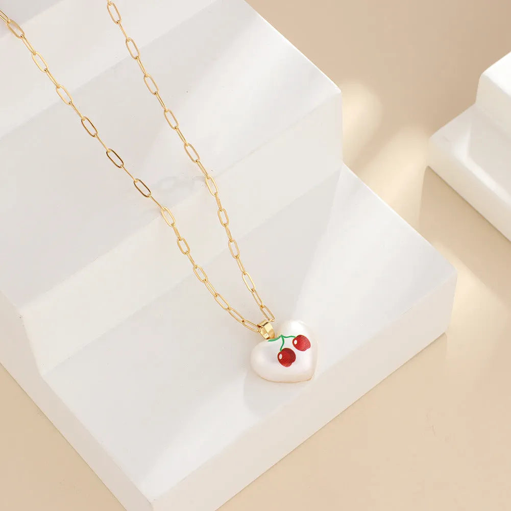 Adjustable heart necklace showing geometric fruit pendants: apple, pineapple, strawberry, cherry, and pear.