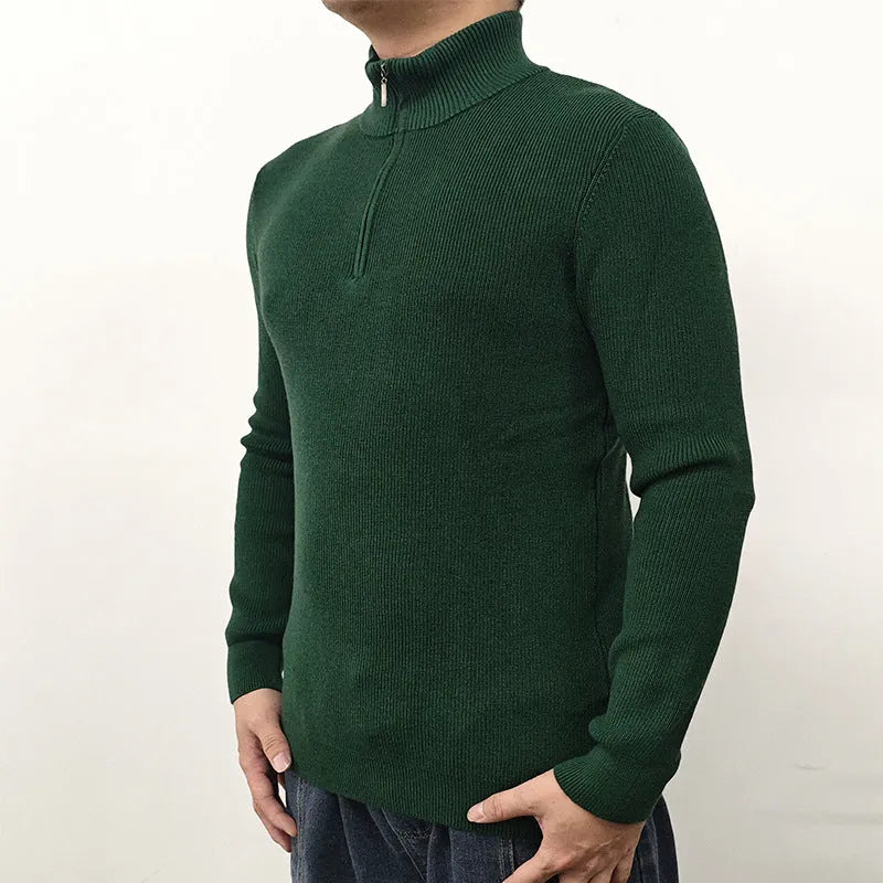 Man wearing a grey zip-up half-turtleneck sweater with long sleeves.