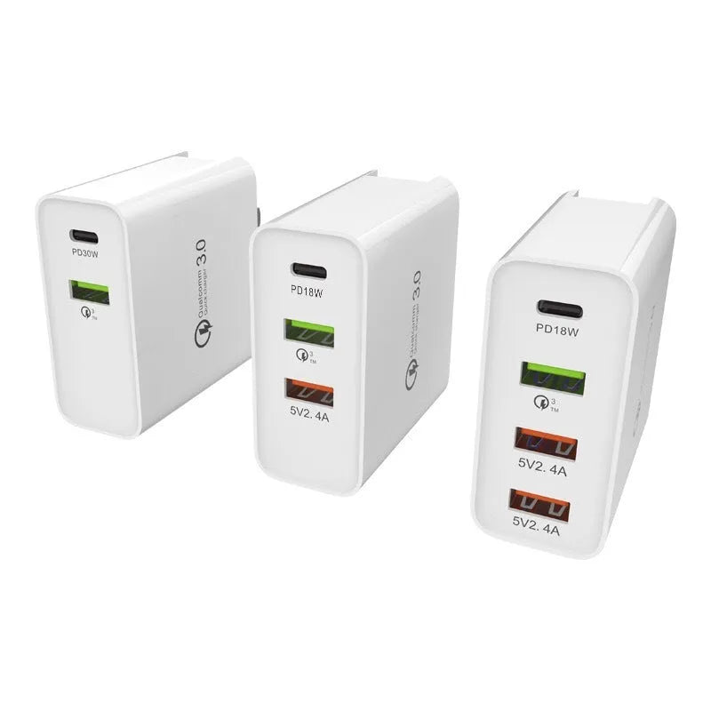White and black multi-port USB fast wall charger with PD and QC 3.0 support on a table.