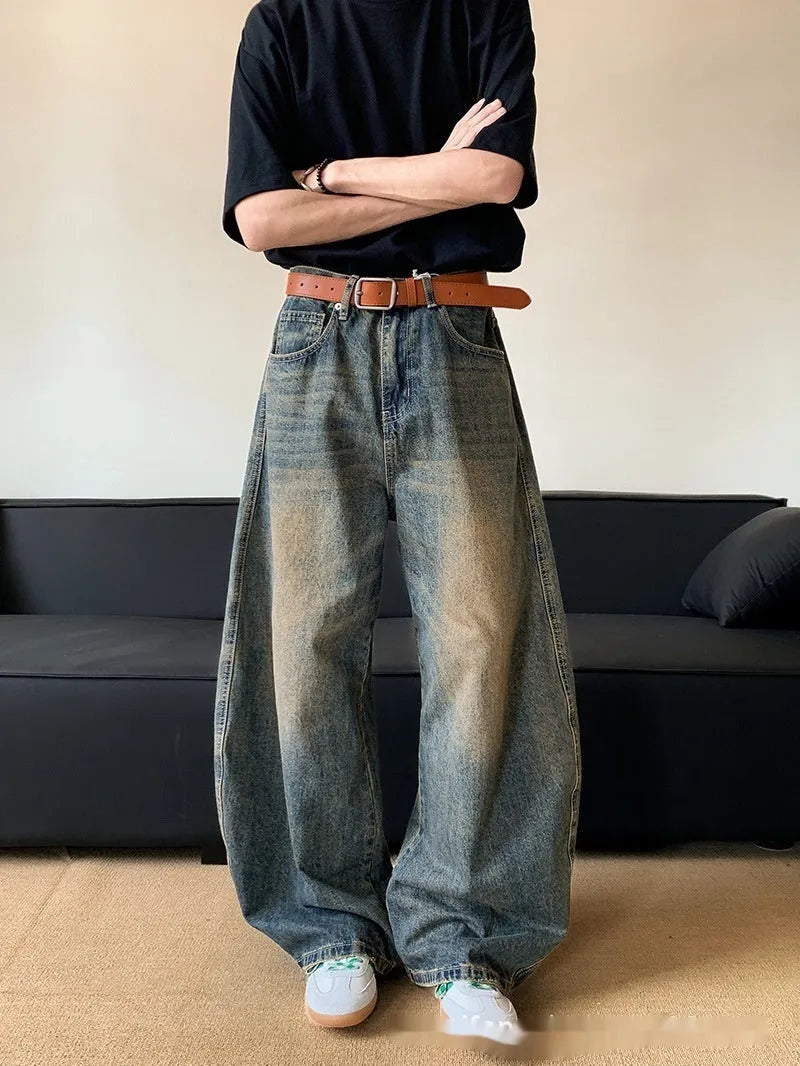 Men modelling retro blue distressed wide-leg jeans with machete detailing and a slimming fit.
