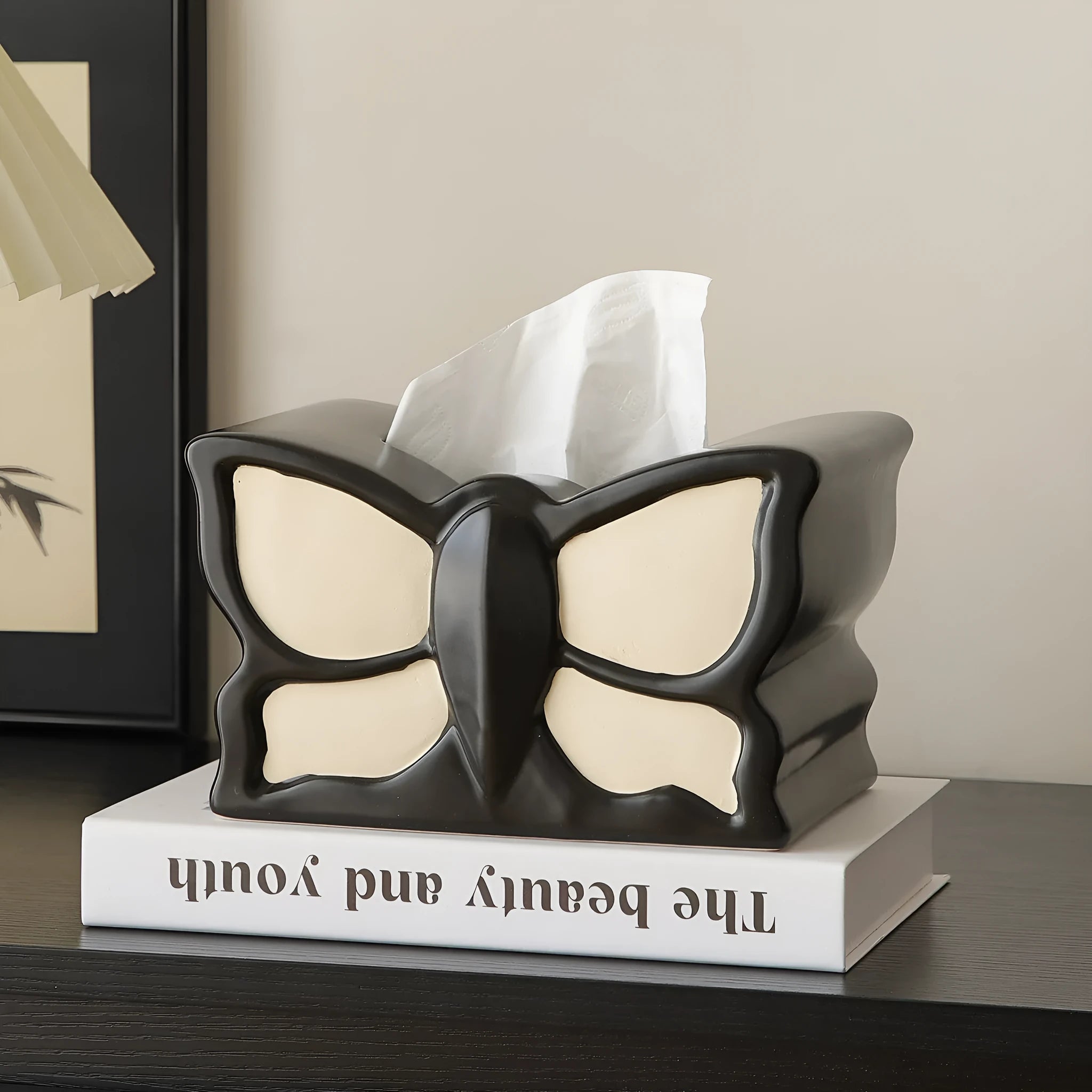 Ceramic butterfly vase and matching tissue box set on a living room table.
