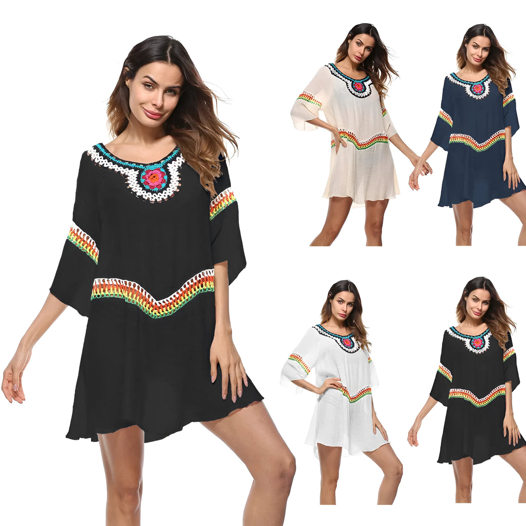 Female model wearing a crocheted ethnic style white sun protection cover-up on the beach.