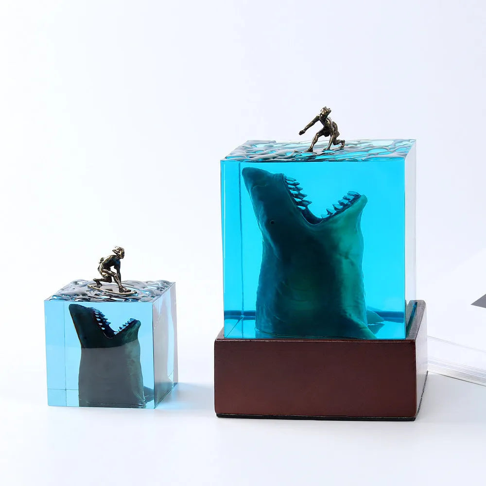 Clear epoxy resin ornament with shark surfing scene inside, on a plastic lamp holder base.