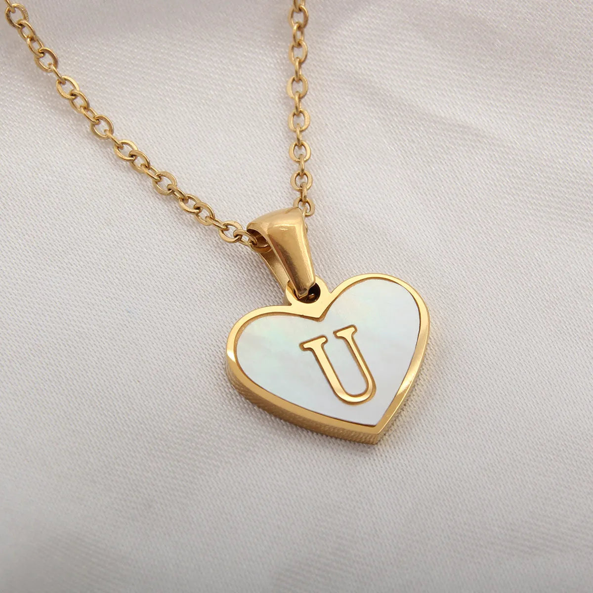 Gold plated initial necklace with white shell heart pendant and adjustable chain