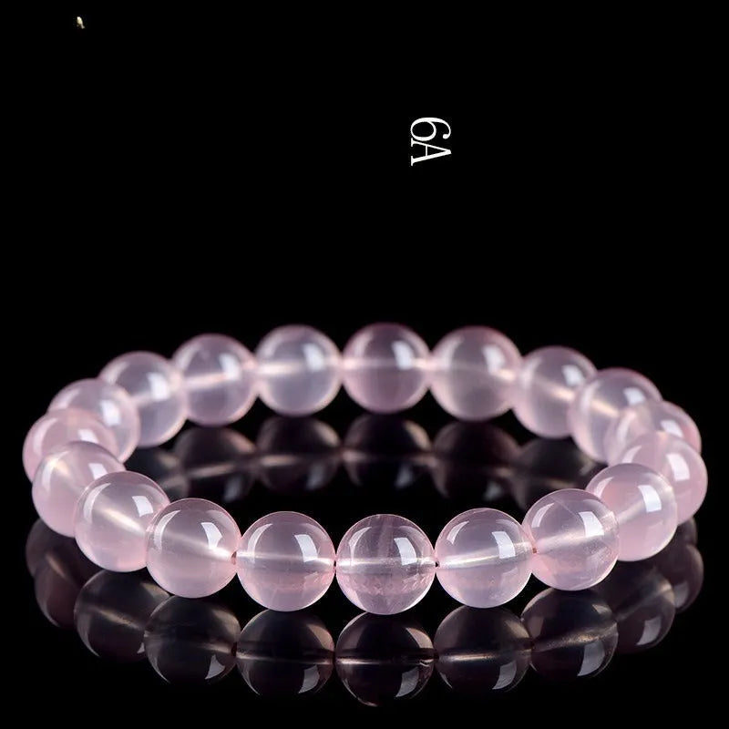 Natural starlight crystal round beads bracelet for women in pink, showing polished beads on a wrist.